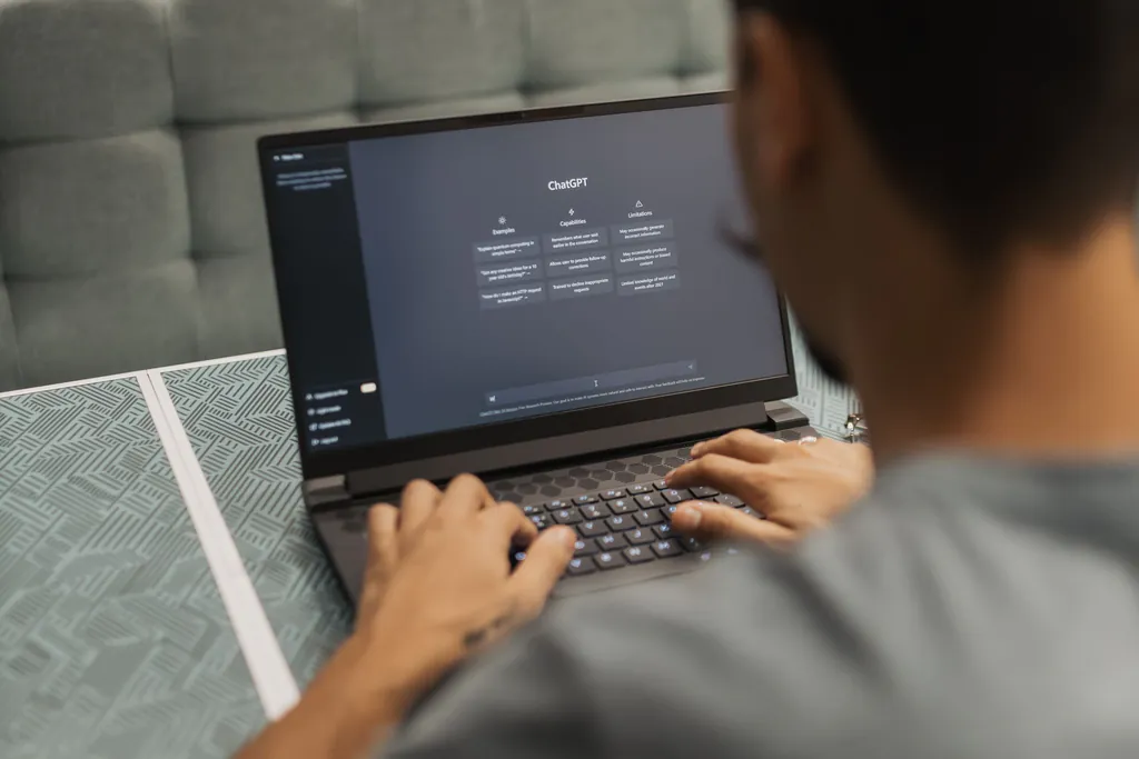 Over-the-shoulder view of a staff member typing into a ChatGPT chat window on a laptop